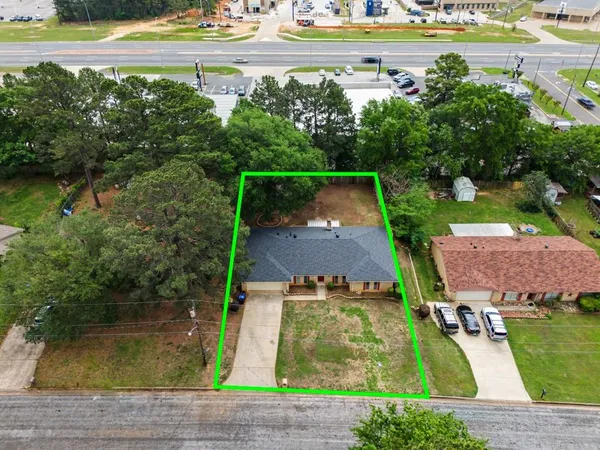 an aerial view of a house with swimming pool and a yard