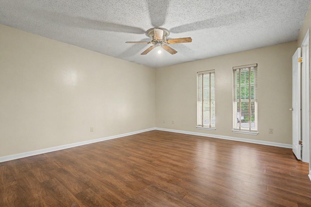 2104 Wainwright Court Longview, TX 75605 - Photo 4 of 31 an empty room with wooden floor fan and windows