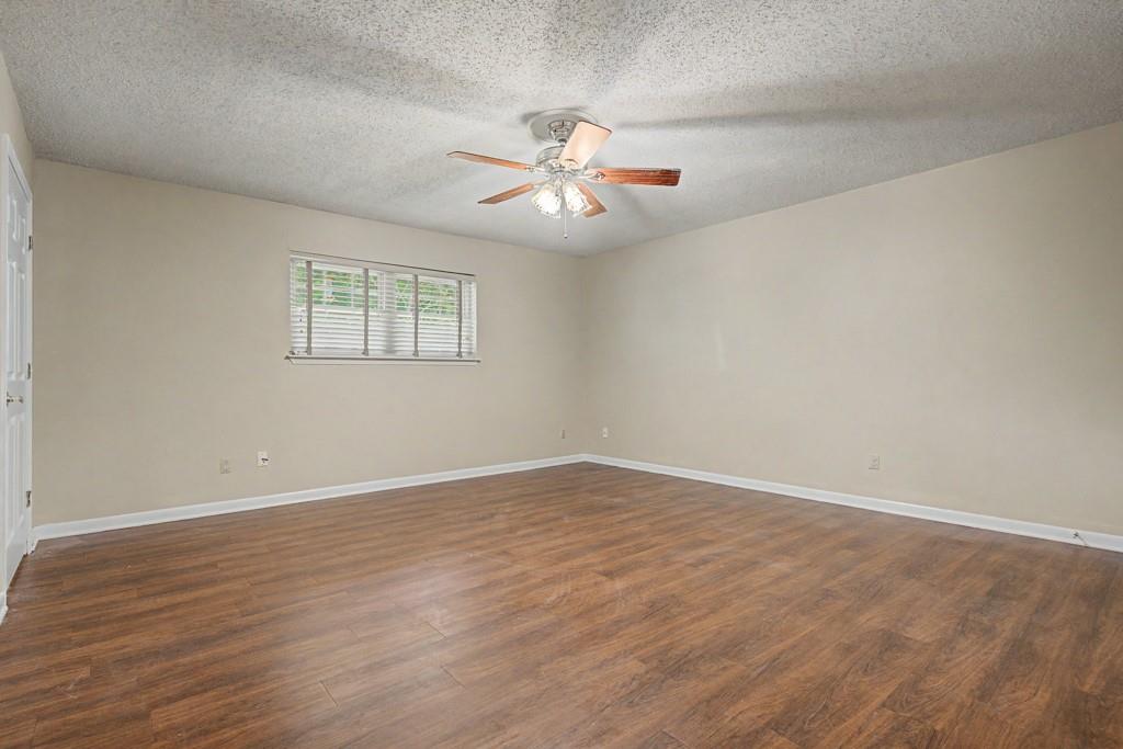 2104 Wainwright Court Longview, TX 75605 - Photo 6 of 31 an empty room with wooden floor ceiling fan and window