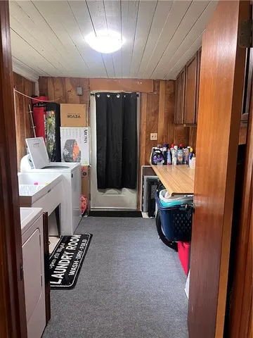 a storage room with water heater and refrigerator