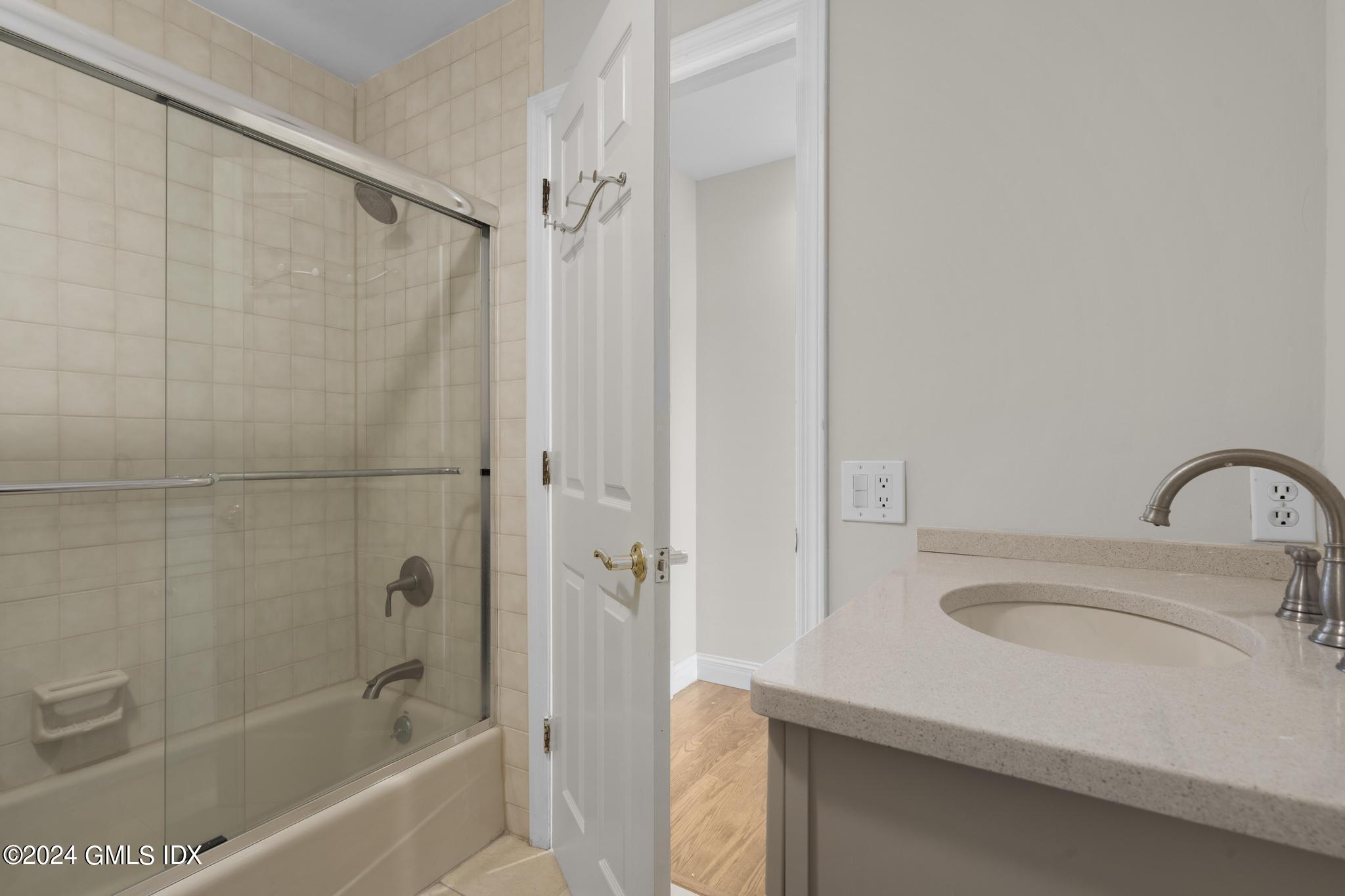 172 Field Point Road, Unit 1 Greenwich, CT 06830 - Photo 26 of 36 a bathroom with a sink a mirror and a bathtub