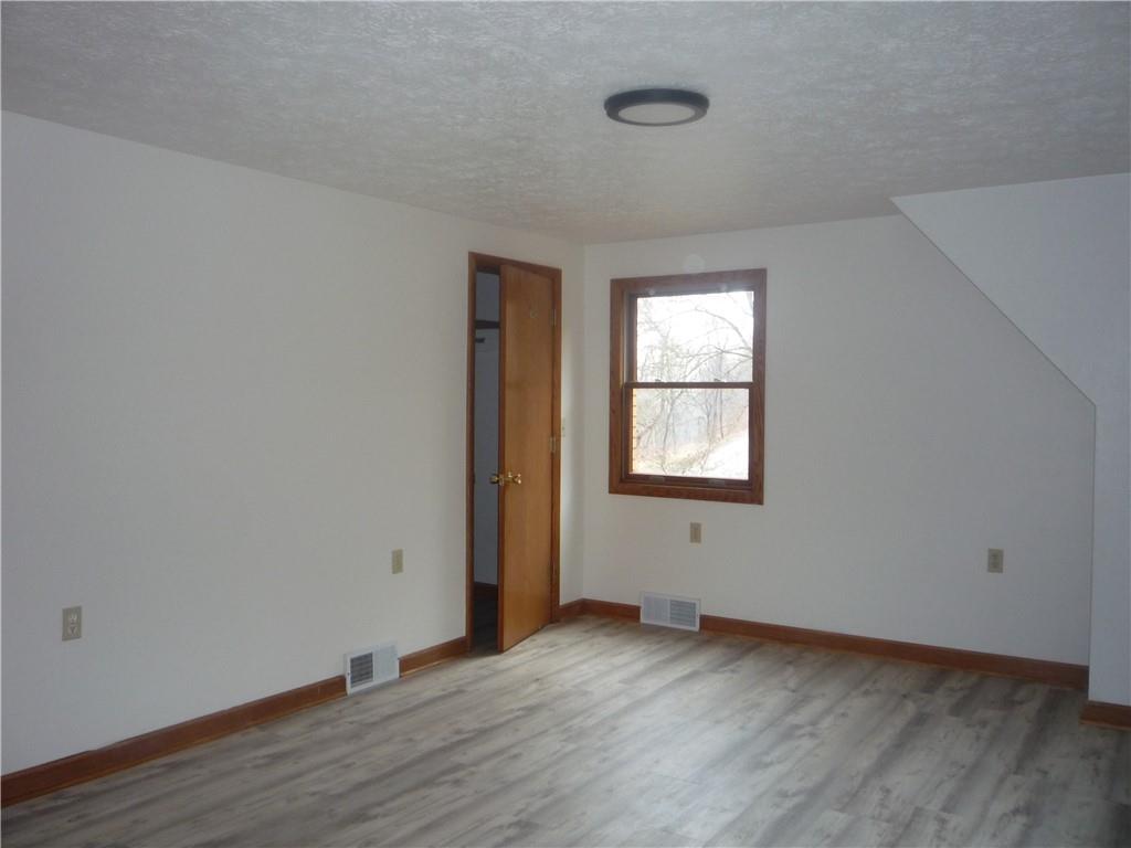 4465 Mt Troy Rd Extension, Unit 2 Pittsburgh, PA 15214 - Photo 18 of 36 an empty room with wooden floor and windows