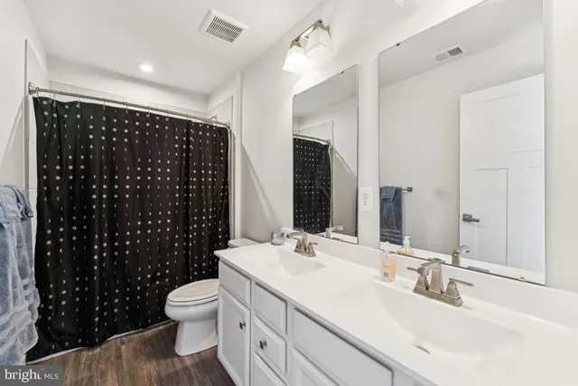 a bathroom with a double vanity sink toilet and shower