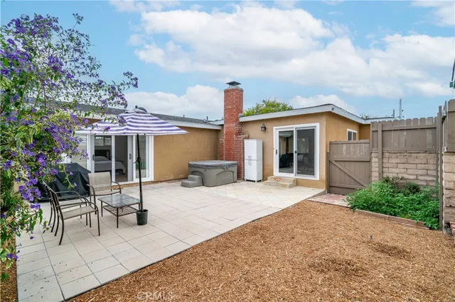 a patio with a table and chairs and potted plants