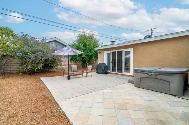 a view of a patio with a table and chairs under an umbrella