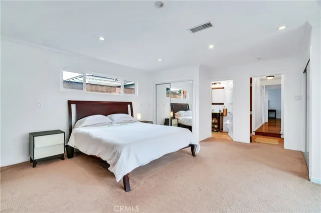 a spacious bedroom with a bed and a cabinets