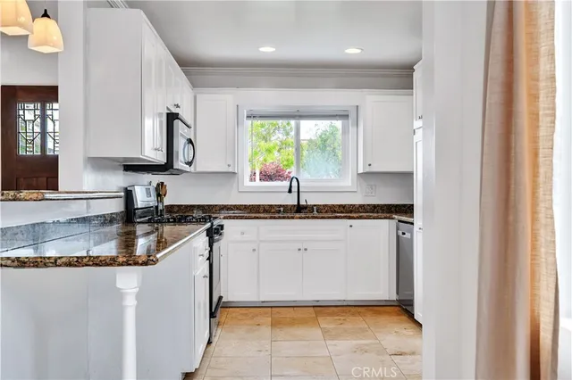 a kitchen with stainless steel appliances granite countertop a sink stove and cabinets