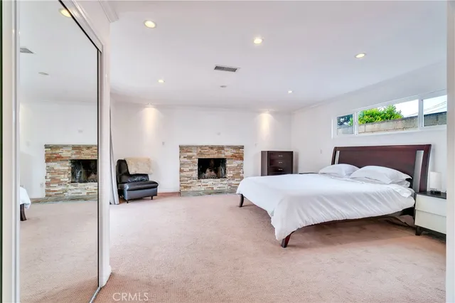 a spacious bedroom with a bed and a fireplace