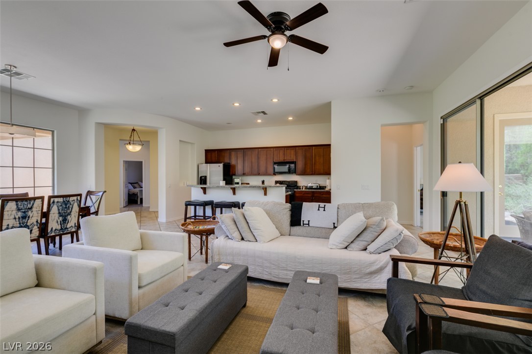 8 Kennesaw Road Henderson, NV 89052 - Photo 20 of 44 An open concept living area seamlessly blends into the kitchen and dining spaces, featuring recessed lighting and outdoor access.