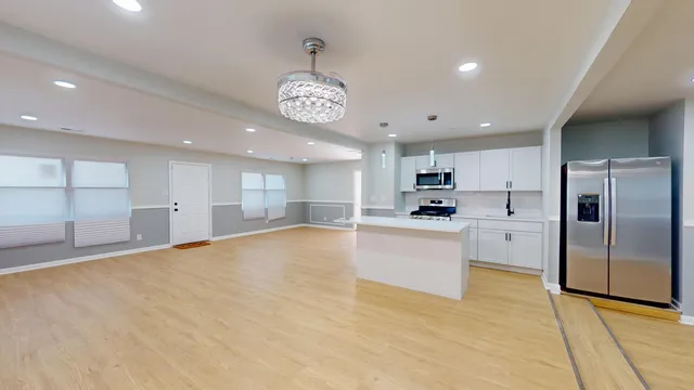 a view of kitchen with a refrigerator a microwave and a sink