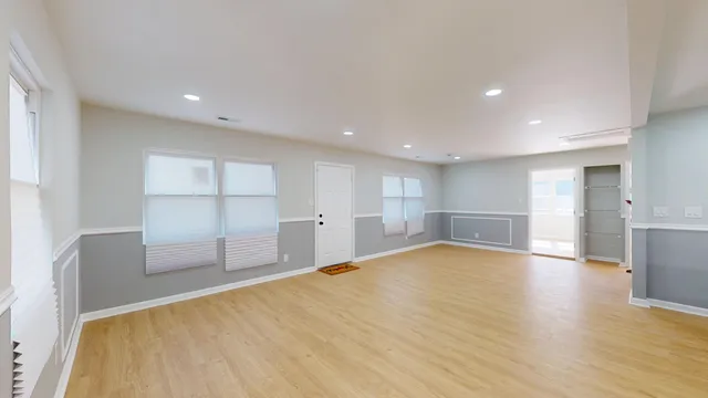 a view of empty room with wooden floor