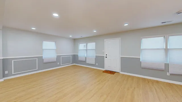 a view of empty room with wooden floor