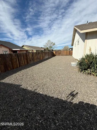 a view of backyard with wooden fence