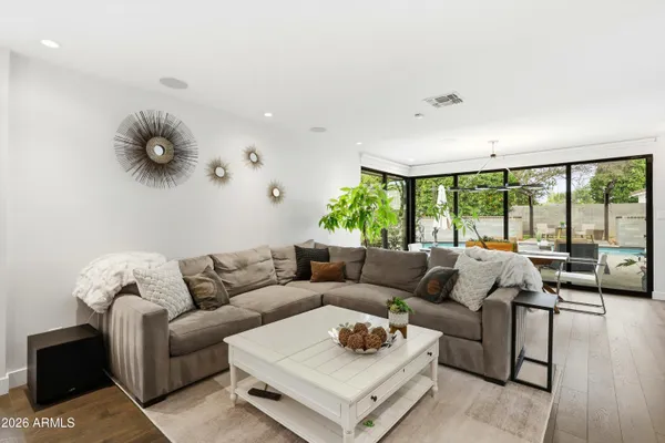 a living room with a large window wooden floor and furniture