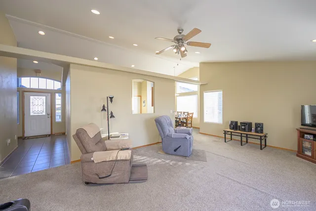 a living room with furniture and a ceiling fan