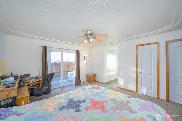 a spacious bedroom with a bed and a chandelier