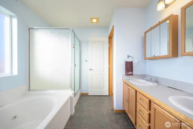 a bathroom with a granite countertop sink and a bathtub