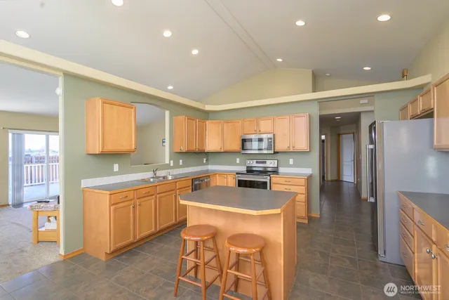 a kitchen with a sink a counter top stainless steel appliances and cabinets