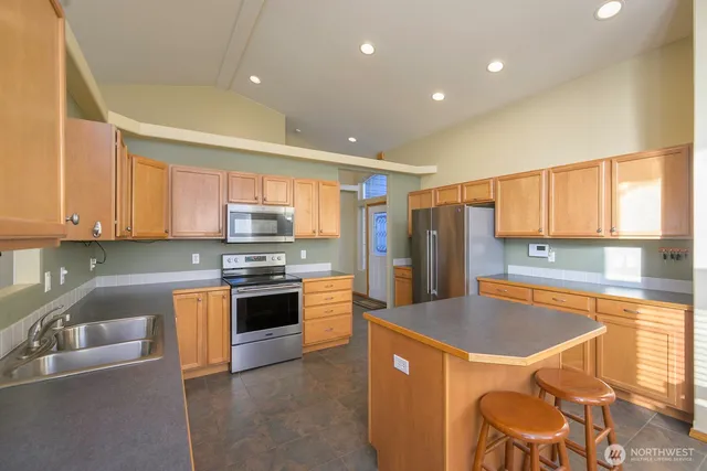 a kitchen with stainless steel appliances granite countertop a sink stove and refrigerator