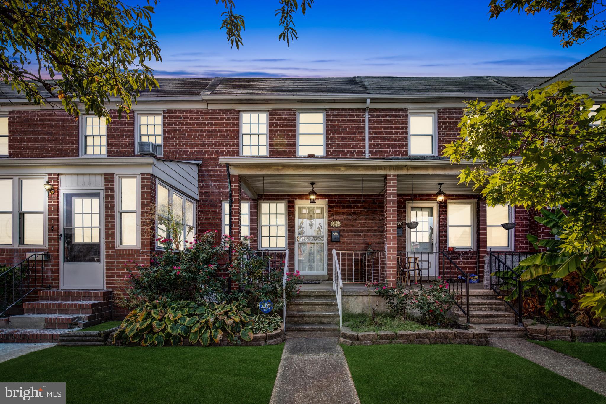 a view of house with a yard and potted plants