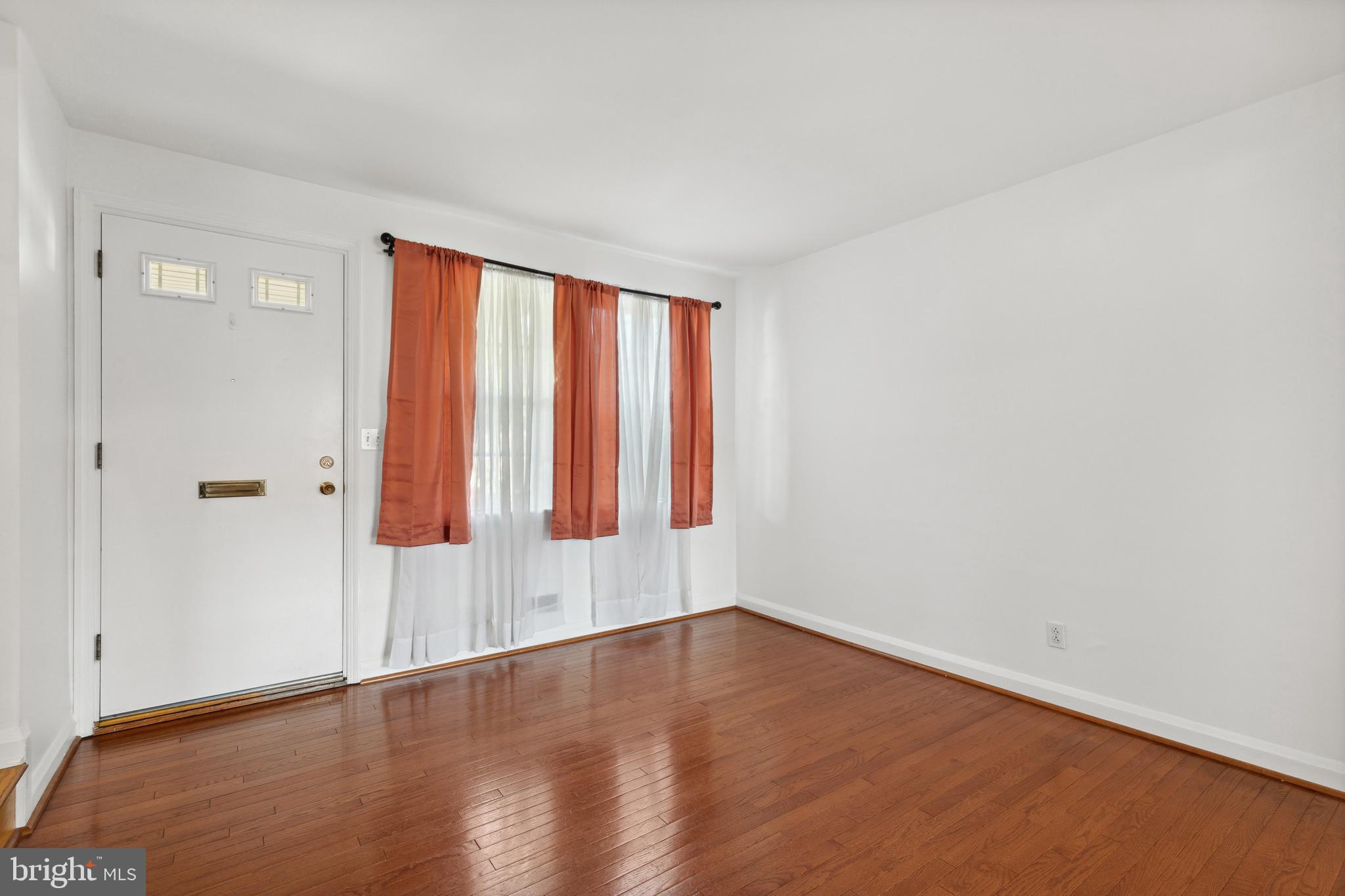 3418 Dunran Road Dundalk, MD 21222 - Photo 13 of 53 a view of an empty room with wooden floor and a window