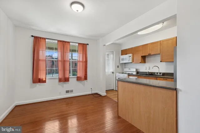a kitchen with a sink wooden floor and a window