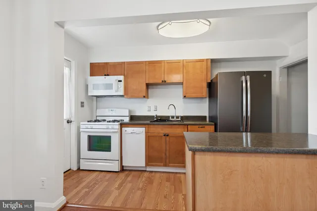 a kitchen with stainless steel appliances granite countertop a sink and a stove