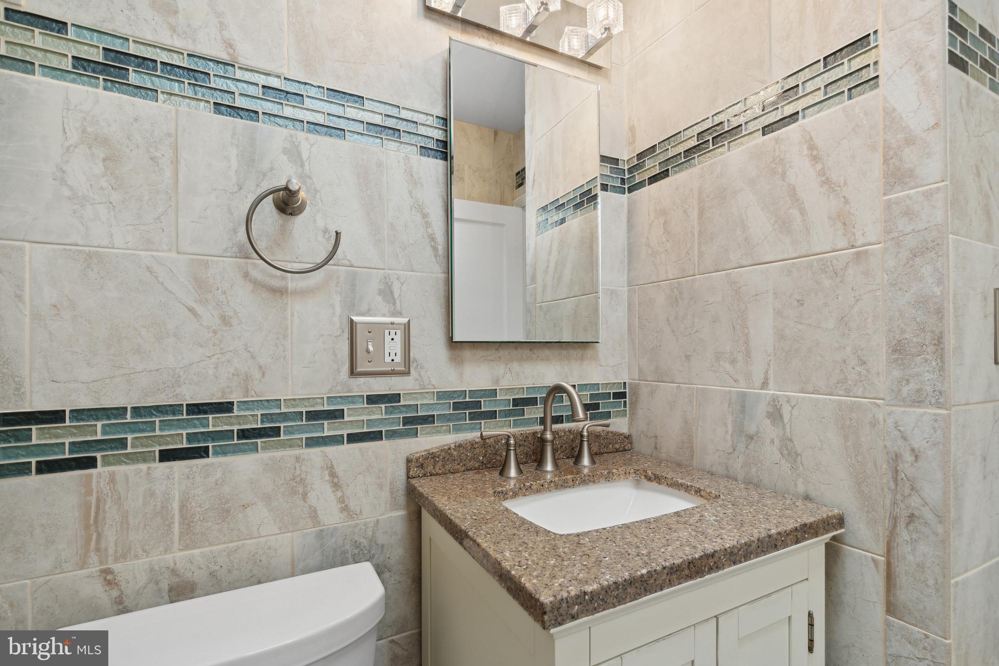 3418 Dunran Road Dundalk, MD 21222 - Photo 41 of 53 a bathroom with a granite countertop sink a toilet and a mirror