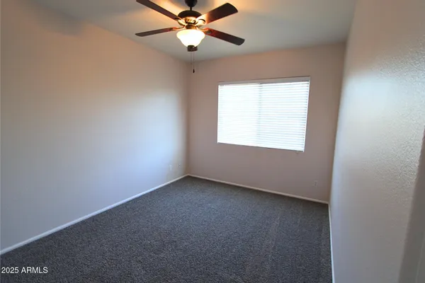 an empty room with a chandelier fan