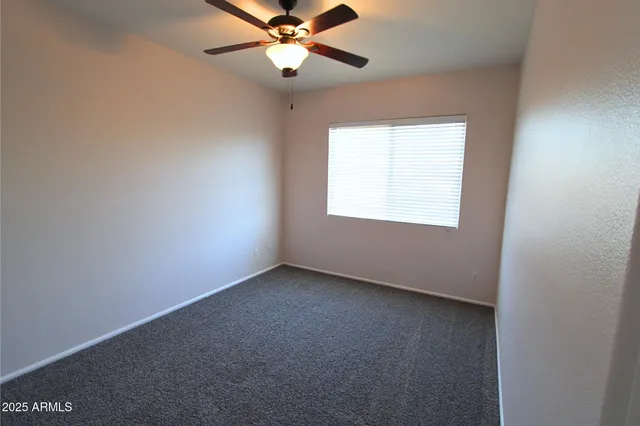 an empty room with a chandelier fan