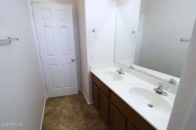 a bathroom with a double vanity sink and mirror with shower