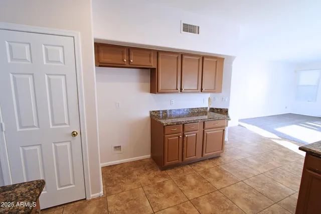 a kitchen with granite countertop a sink and cabinets