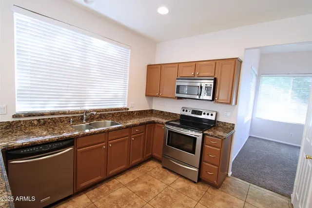 a kitchen with stainless steel appliances granite countertop a sink stove and microwave