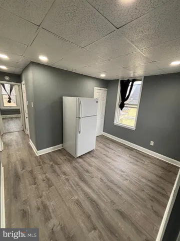 an empty room with windows and cabinet