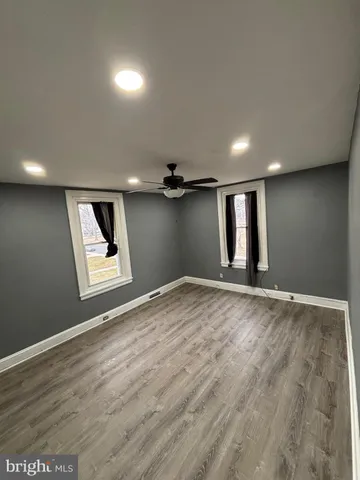 a view of empty room with wooden floor