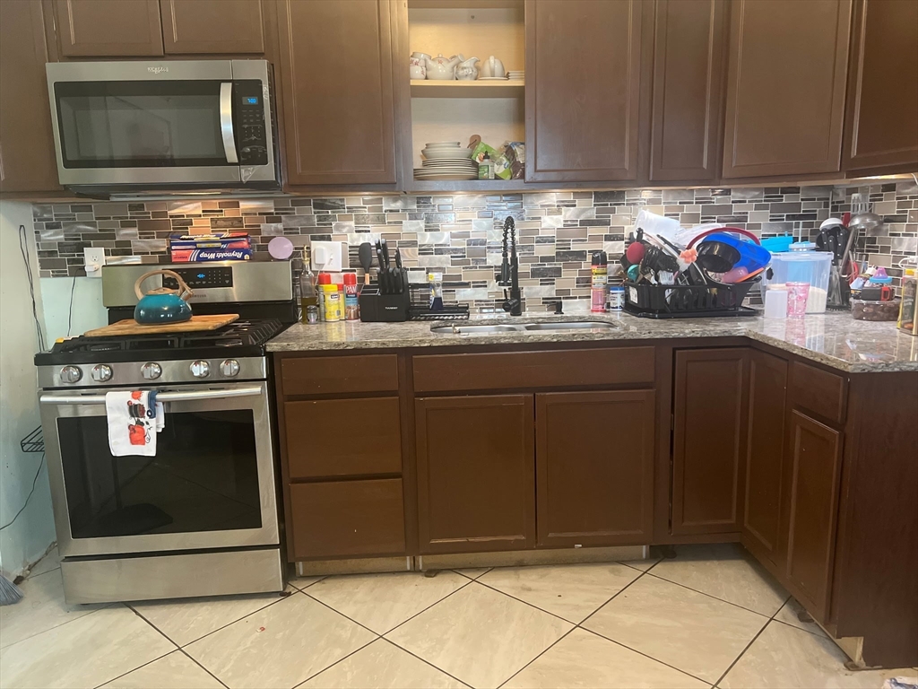 103 Warren Street Lynn, MA 01905 - Photo 4 of 24 a kitchen with stainless steel appliances granite countertop a sink stove and microwave