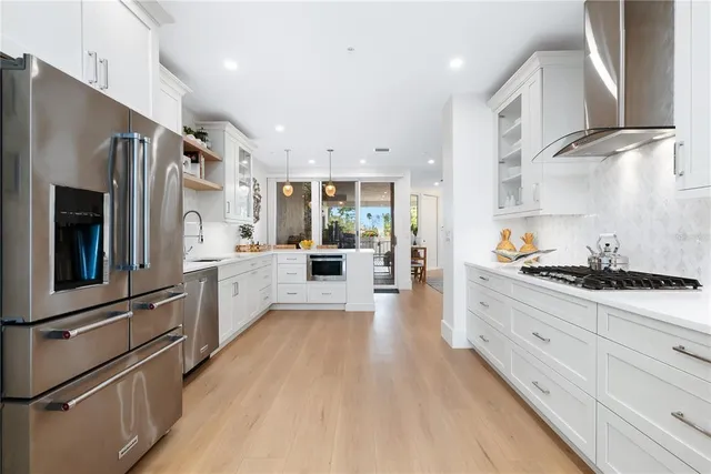 a large kitchen with stainless steel appliances sink a stove and cabinets
