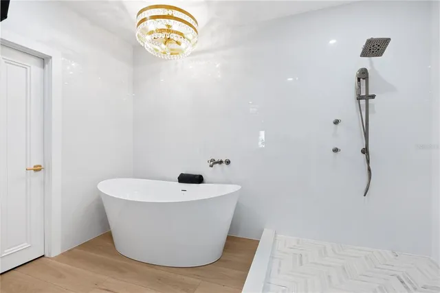 a white tub sitting next to a shower