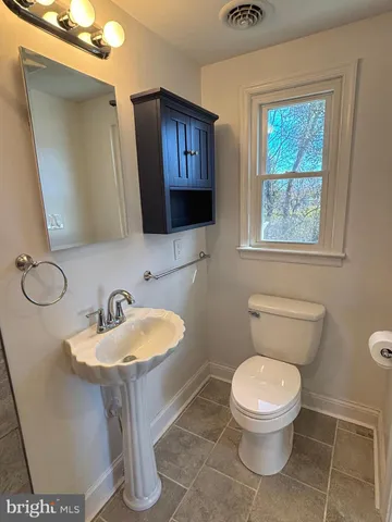 a bathroom with a toilet sink and mirror
