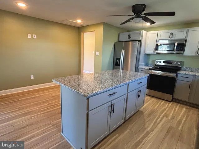 a kitchen with stainless steel appliances granite countertop a sink and a stove