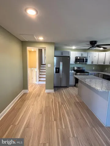 a kitchen with stainless steel appliances granite countertop a refrigerator and a stove top oven