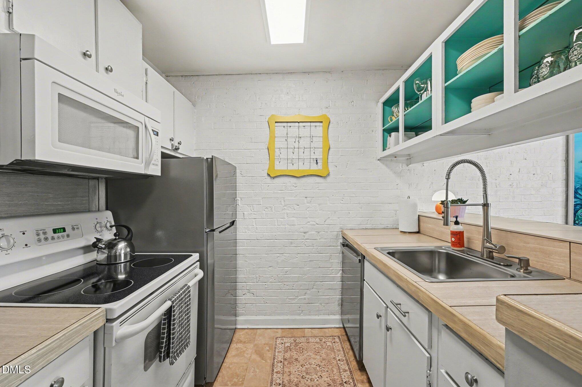 807 West Trinity Avenue, Unit 252 Durham, NC 27701 - Photo 6 of 23 a kitchen with stainless steel appliances a sink stove and refrigerator