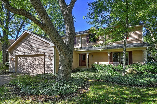 a view of a house with brick walls and a tree