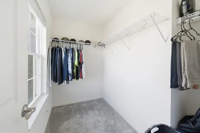 a view of walk in closet with clothes