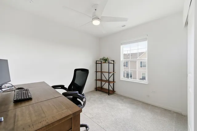 a view of a workspace with furniture and a window