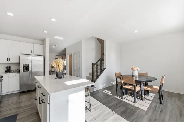 a kitchen with refrigerator and chairs