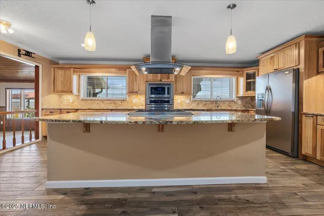 a kitchen with stainless steel appliances granite countertop a sink a stove and a refrigerator