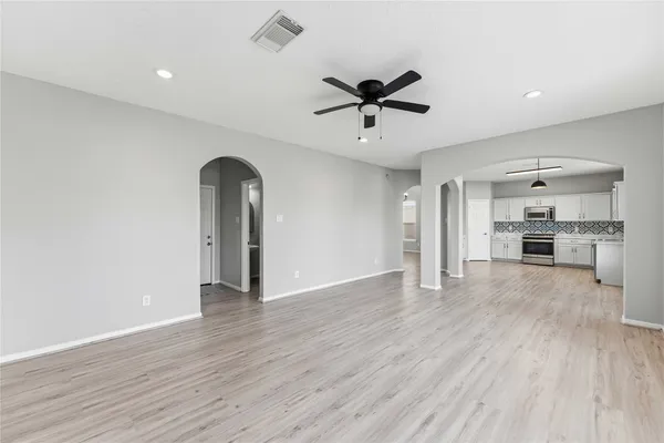 a view of empty room with wooden floor and window