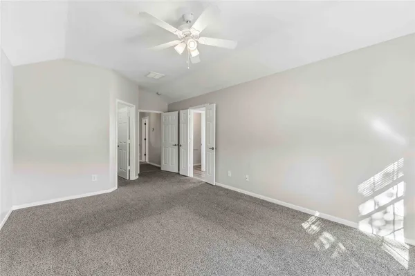 a view of a big room with windows and chandelier fan