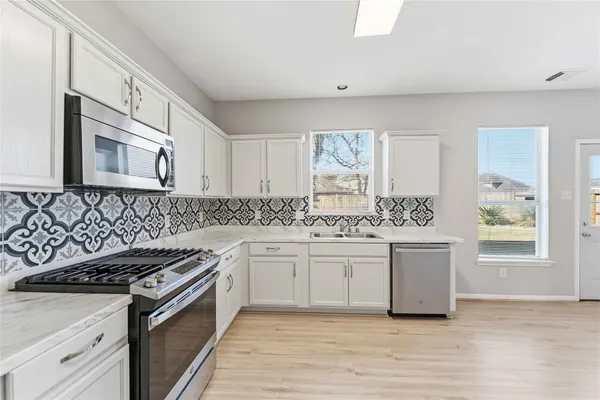 a kitchen with stainless steel appliances granite countertop a stove and a sink